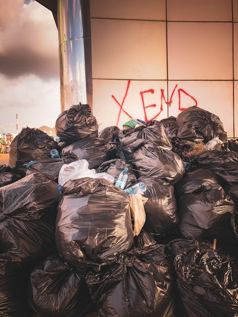 A large blue metal container filled with a substantial pile of used black rubber tires, stacked haphazardly with some tires leaning and overlapping each other. The tires vary slightly in size but are